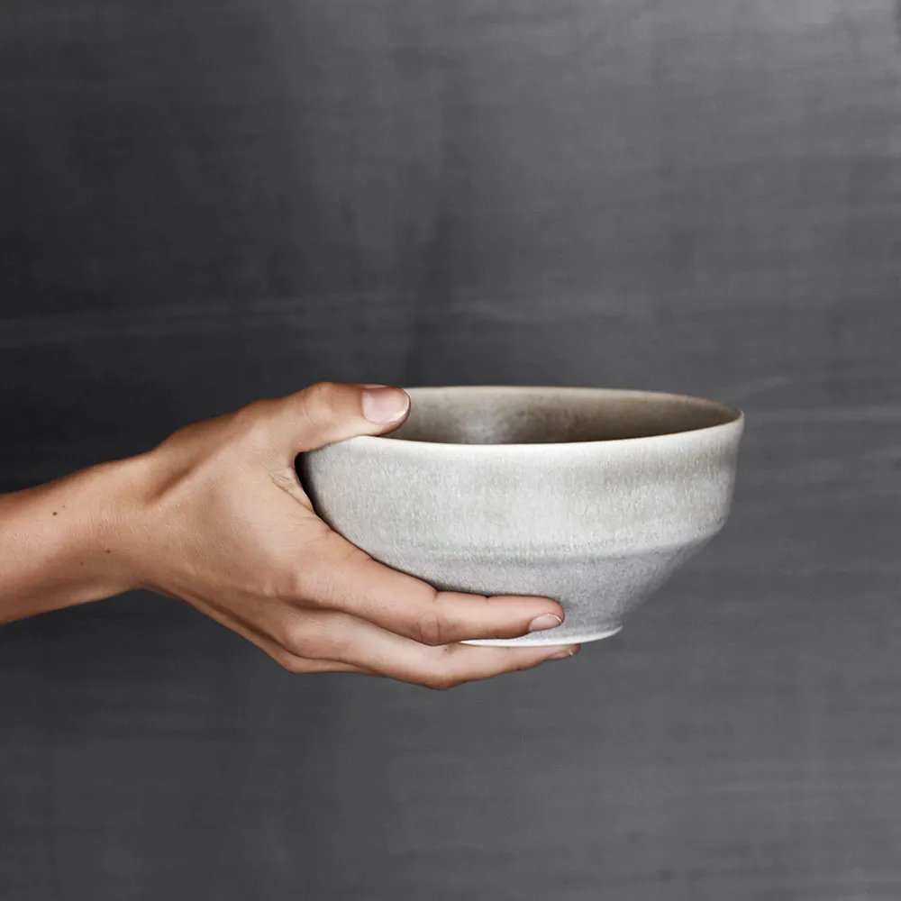 Ceto morgenmadsskål i farven soft grey fra Muubs holdt i hånden
