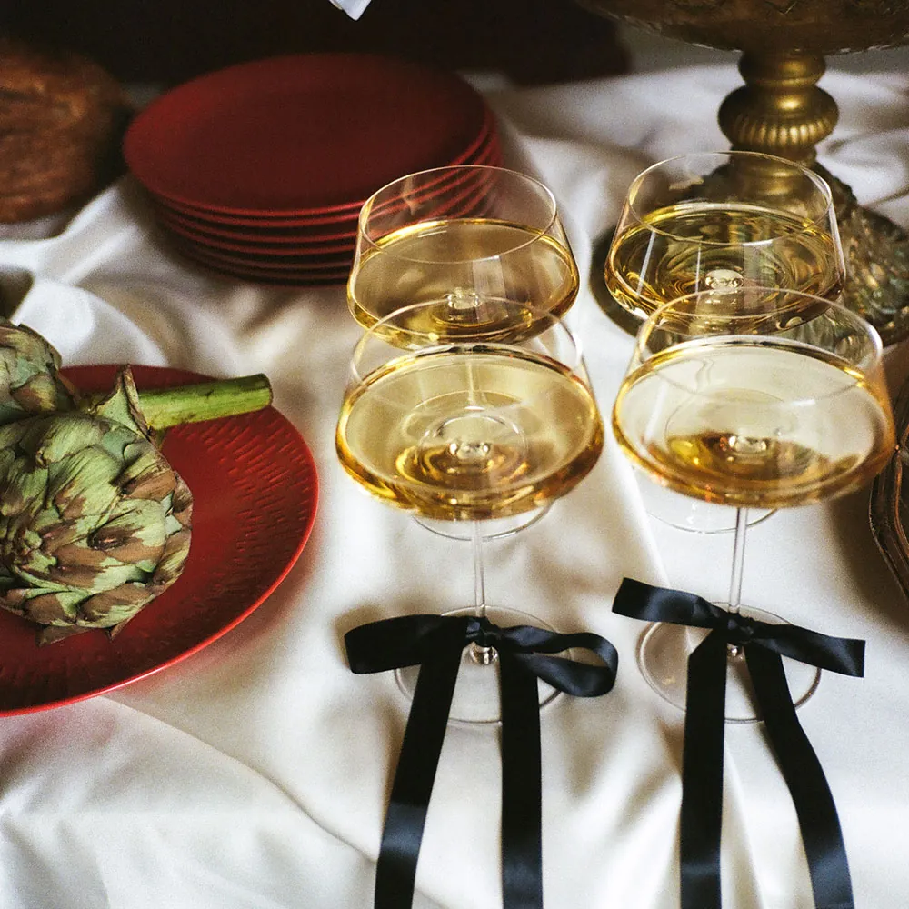 4 Aida Ultima cocktailglas med væske i og sorte sløjfer om stilken