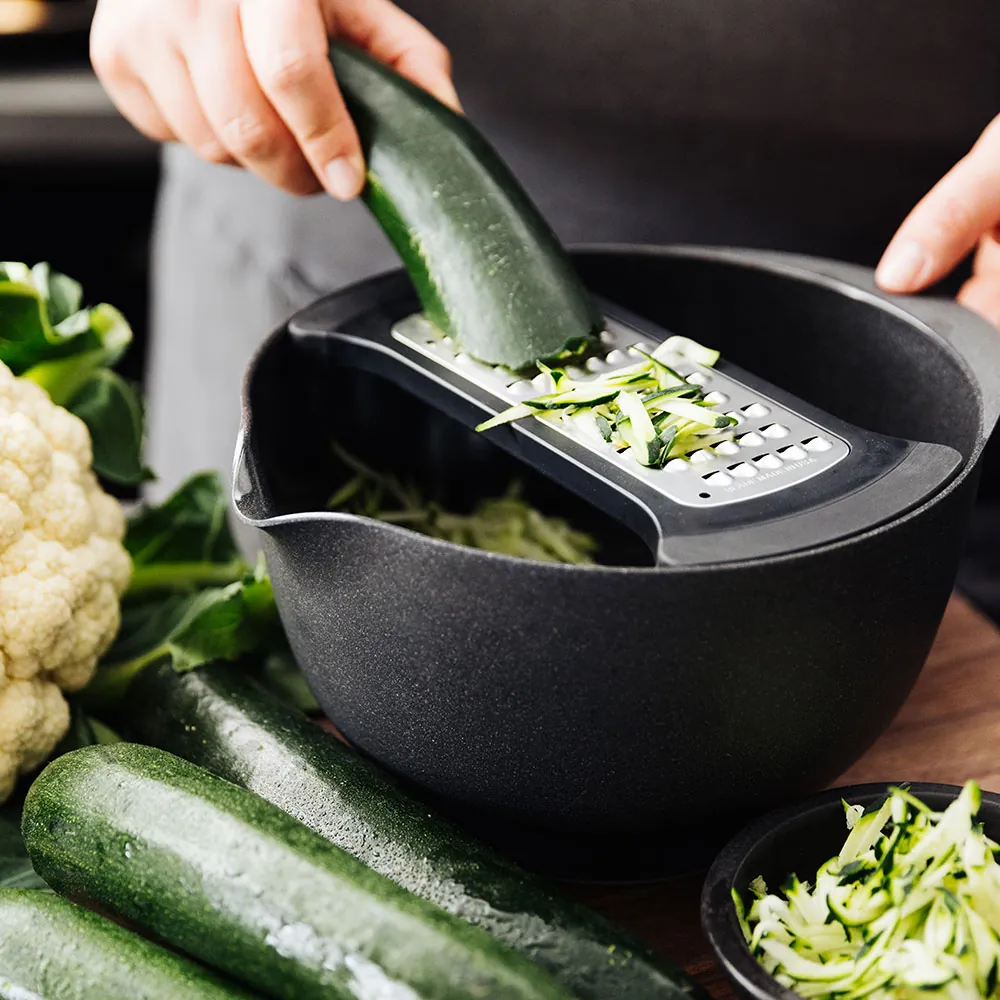 Person anvender Microplane coarse bowl grater til at rive squash
